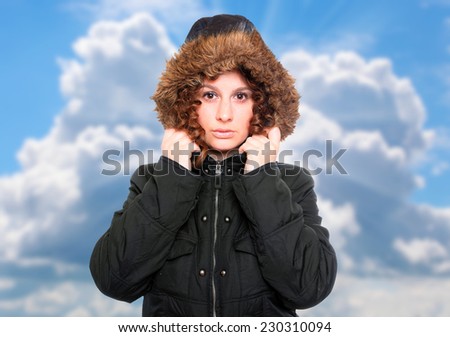 Young woman dressed in warm jacket with fur hood for frosty weather.
