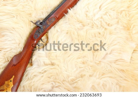 Close up of hunting gun on a sheep fur.