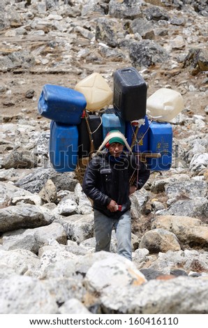 EVEREST REGION,NEPAL- APRIL 23:Unidentified sherpa  carry heavy load in the Himalaya at Everest Base Camp trek on April 23,2013 in Everest region,Nepal.Sherpas are elite mountaineers in Himalayas.