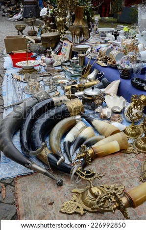 TBILISI, GEORGIA - SEPTEMBER 16, 2014: Souvenirs and retro items sold on the Dry Bridge Market with traditional drinking horns used for wine on foreground in Tbilisi,Georgia