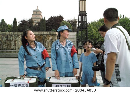 On July 31, 2014, in China, xi \'an wild goose pagoda scenic area, dressed in a red guards, selling old Popsicle work-study programs of the female college students to the tourists.