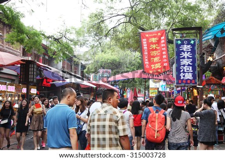 On December 7, 2014, tourists in xi \'an hui street cuisine street to watch the food production. Xi \'an hui street is one thousand food court, and the place where visitors will visit to xi \'an.