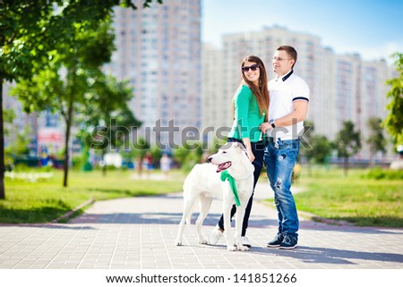 Happy couple with a dog having fun outdoors in the city