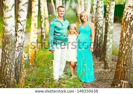 Young family in the forest at sunset