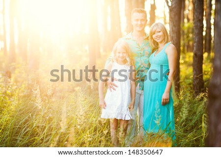 Young family in the forest at sunset