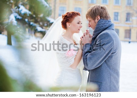 Gentle bride and groom. Beautiful white wedding in the winter.