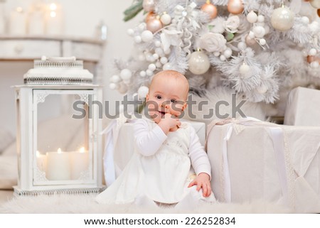 Little girl near the Christmas tree. Christmas morning, searching for gifts. Luxury interior.