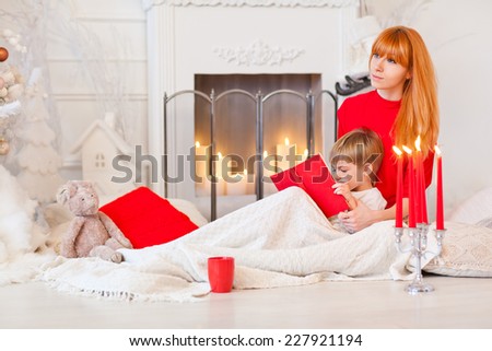 Mom reading bedtime stories for her son. Christmas Eve. Tales of the fireplace.