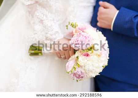 Close-up photo bride\'s bouquet on the background of the bride and groom. The bride\'s bouquet. Peonies. Trendy bouquet.