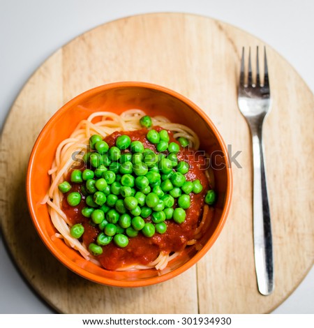 green peas on vegan noodles with tomato sauce. selective focus, top view