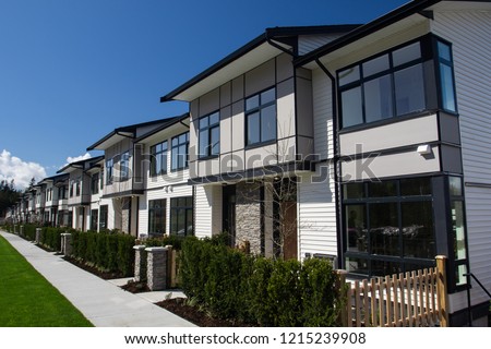 Residential townhouses on blue sky background on sunny day. External facade of a row of colorful modern urban townhouses.brand new houses just after construction on real estate market