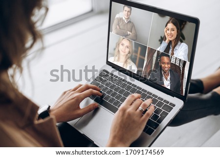 Online business meeting. Business team working from home in a video conference. The girl communicates via video call communication using laptop with her business colleagues about the future strategy