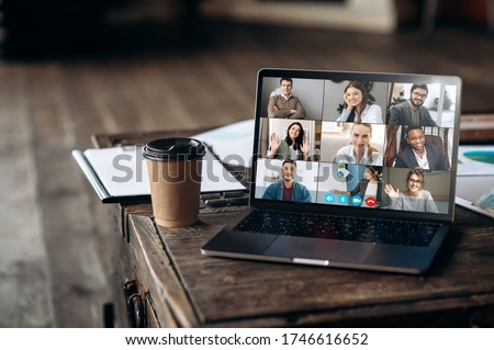 Virtual meeting online. Video conference by laptop. Online business meeting. On the laptop screen, people who gathered in a video conference to work on-line, near stands a cup of coffee