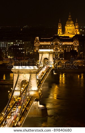 Chain Bridge and St Stephen Basilica at night, Budapest. Visible boats movement on the Danube River