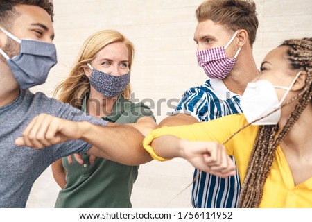 Young friends wearing face mask doing new social distancing greet with elbows bumps for preventing corona virus spread - Physical distance and friendship safety greetings concept 