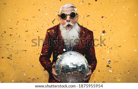 Crazy senior man having fun doing party during holidays time - Elderly people celebrating life concept 