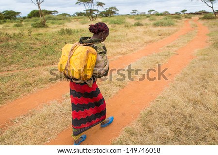 GAYO VILLAGE, ETHIOPIA - JUNE 19: Woman with a can of water from a nearby well (called Ella) on her way back to her village on June 19, 2012 in Gayo village, Ethiopia.