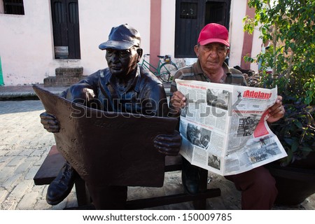 CAMAGUEY, CUBA - MARCH 11: Unidentified man poses next to a sculpture shaped of himself on March 11, 2011 in Camaguey, Cuba. Sculptures on the street show inhabitants of the city.