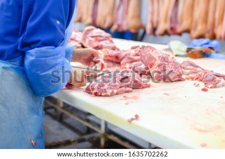 Meat deboning shop. Butcher. Butchers are cutting pork. Line of production of sausage delicacies. Сток-фото © 