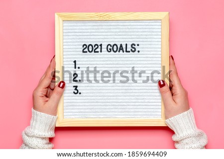 female hands holds felt board with text - 2021 goals on pink background Planning, self motivation, achievement, success, wish list, checklist concept Top view Flat lay Motivational quote, message 商業照片 © 