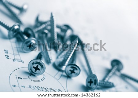 metal screws over technical drawing background