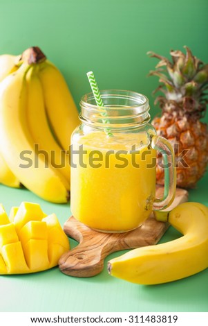 healthy yellow smoothie with mango pineapple banana in mason jars