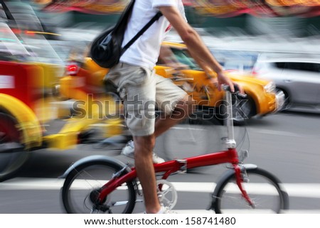 cyclist in traffic on the city roadway < motion blur >