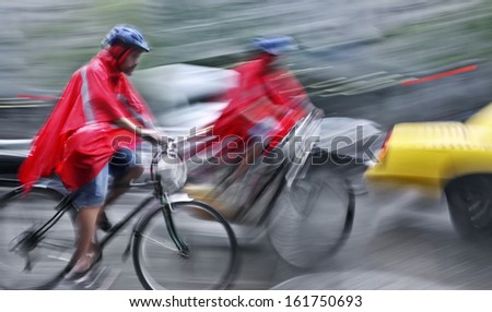 cyclist in traffic on the city roadway < motion blur >