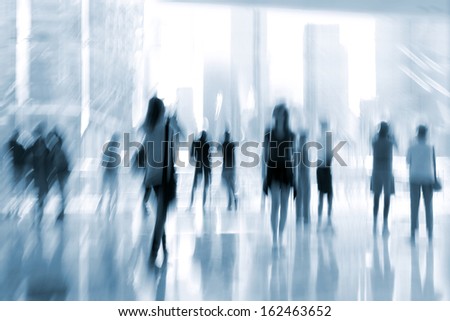 abstract image of people in the lobby of a modern business center with a blurred background  and a blue tonality