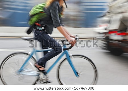 cyclist in traffic on the city roadway  motion blur