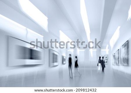 abstract image of people in the lobby of a modern art center with a blurred background and blue tonality