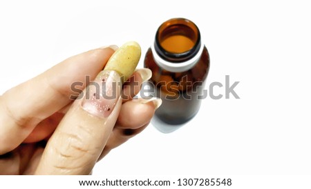 hand holding pill vitamin c pouring from a light protection bottle isolated on white background with copy space. Vitamin supplements, antioxidants Imagine de stoc © 