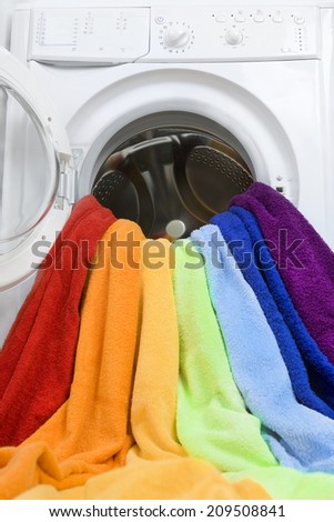 Washing machine and colorful laundry to wash (creative concept)