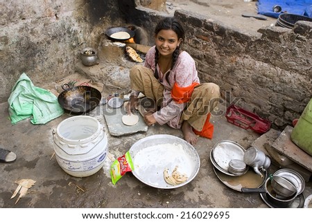 JAIPUR, INDIA - MARCH 02: Unidentified indian poor girl cooking chapatti on March 02, 2013 in Jaipur, India. Chapati - a traditional Indian flatbread