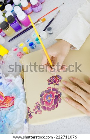 Batik process: artist paints on fabric, Batik-making. An artist paint the floral motif on a batik fabric