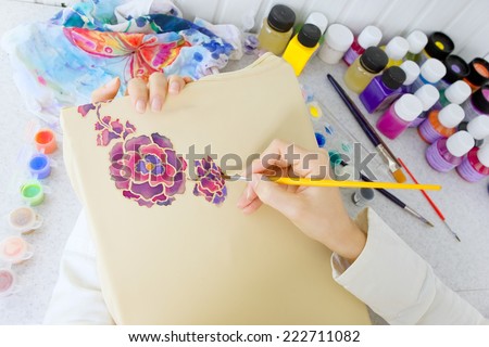 Batik process: artist paints on fabric, Batik-making. An artist paint the floral motif on a batik fabric