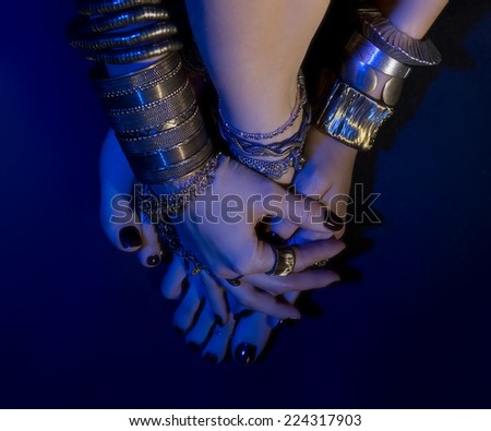 oriental jewelry: female feet and hands with beautiful national indian jewellery, tribal style (blue lens effect)