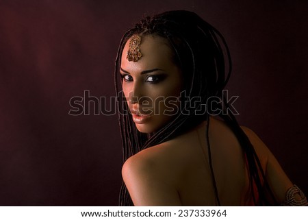 Fashion Beauty. Mystic Make-up. Beautiful Womans With Luxury glossy gold Makeup and stylish hair (dreadlocks) . Beautiful sensitive Girl Face, accessories