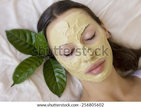 Spa Outdoor, Beautiful young woman lying with natural Indian Multani Matti clay facial mask on her face, skin care and wellness