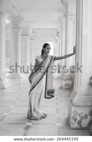 Beautiful young indian woman in traditional clothing with bridal makeup and oriental jewelry. Girl bollywood dancer in Sari posing outdoor near the eastern palace. Eastern fairy tale