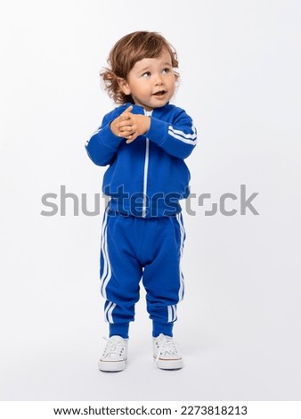 Image, Stock Photo A charming baby is watering a strawberry bush in the garden from a children’s toy watering can. Childhood, sun, summer, gardening