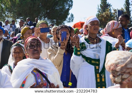 JERUSALEM - NOV 20, 2014: Ethiopian Jewish women mix old tradition of prays, with modern documentation devices, at the Sigd, in Jerusalem, Israel. The Sigd is an annual holiday of the Ethiopian Jews