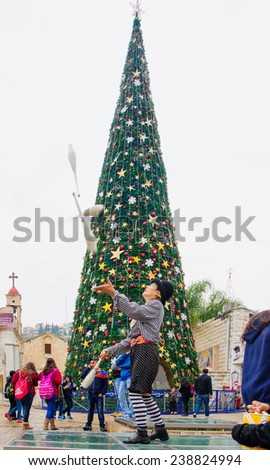 NAZARETH, ISRAEL - December 19, 2014: Jugglers, local and visitors, and a Christmas tree, in the square of the Greek Orthodox Church of Annunciation, in Nazareth, Israel