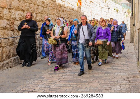 JERUSALEM - APR 10, 2015: Pilgrims from all over the world commemorating the crucifixion of Jesus by carrying a cross along via dolorosa, on orthodox good Friday, in the old city of Jerusalem, Israel