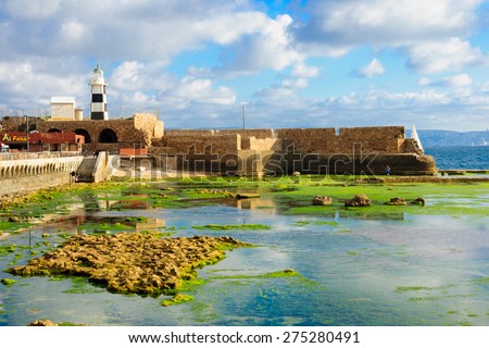 ACRE, ISRAEL - MAY 04, 2015: Scene of a Templar Fortress remains, lighthouse, restaurants, local fishermen and Haifa bay, in the old city of Acre, Israel