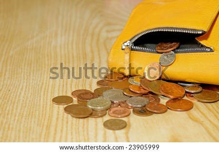 closeup of small change falling out of purse
