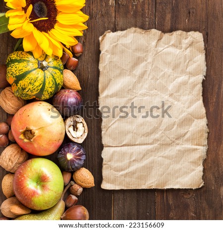 Autumn border made of fruits, vegetables, mushrooms, nuts and sunflower on a wooden table