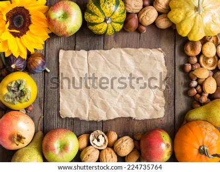 Autumn frame of fruits, vegetables, mushrooms, nuts and sunflower on a wooden table