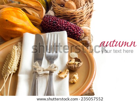 Autumn table setting with corn, nuts and pumpkins