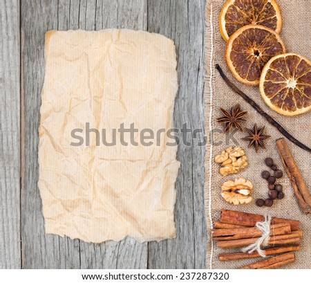 Spices background with paper: dried oranges, all spices, cinnamon, anise, walnuts